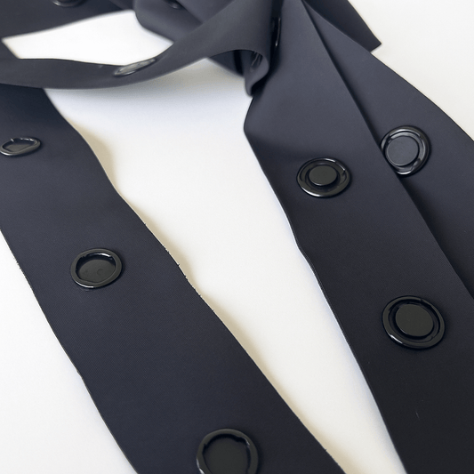 Close-up of black adaptive magnetic fastening tape with round embedded magnets.