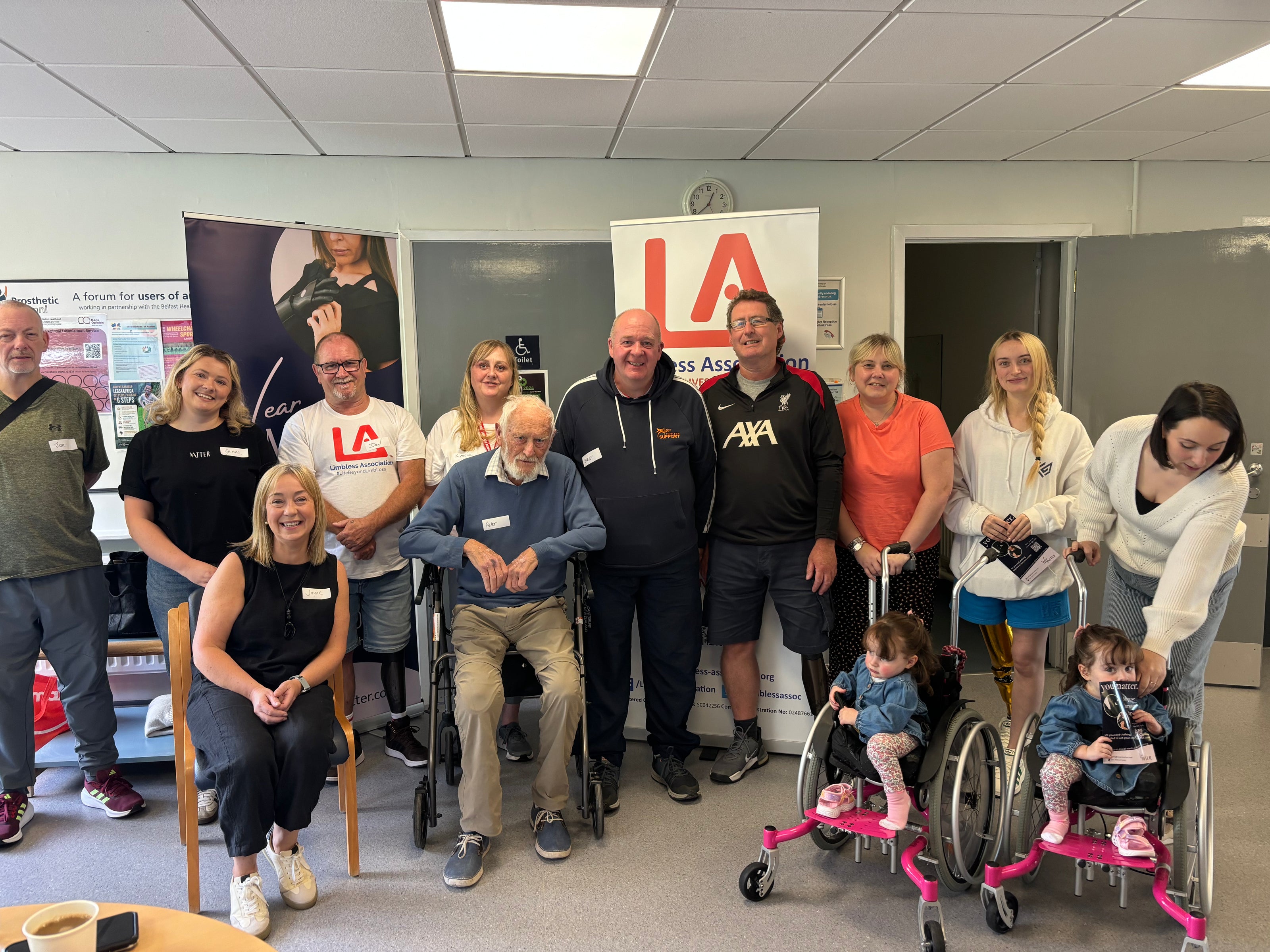 Group photo of Limbless Association members at Musgrave Hospital with WearMatter, including adults and children using mobility aids